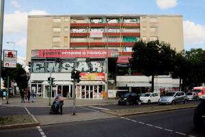 Blick vom Adenauerplatz auf das leere Abbruchgebude. Der Name eines Bauunternehmens prangt an einem Balkongelnder